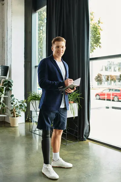 A handsome young professional with an artificial limb confidently works in a contemporary office space. — Stock Photo