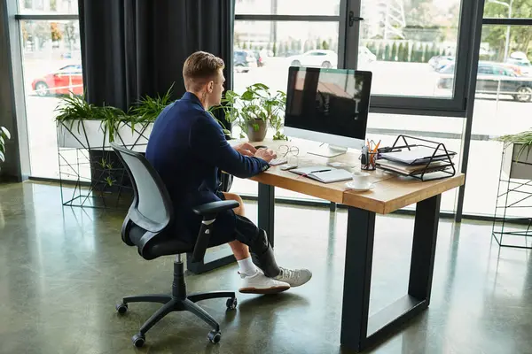 Ein entschlossener Jungprofi mit künstlichen Gliedmaßen konzentriert sich auf seine Arbeit am stilvollen Bürotisch. — Stockfoto