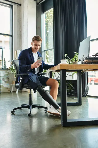 A young, handsome businessman with an artificial limb works on his smartphone, showcasing workplace inclusion. — Stock Photo