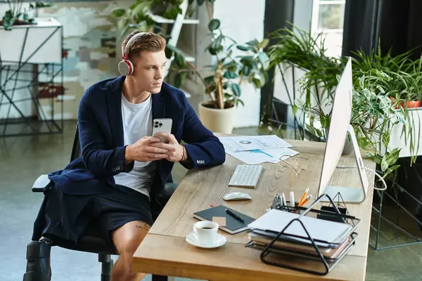 A young businessman with an artificial limb works intently on his smartphone in a bright, modern office. — Stock Photo