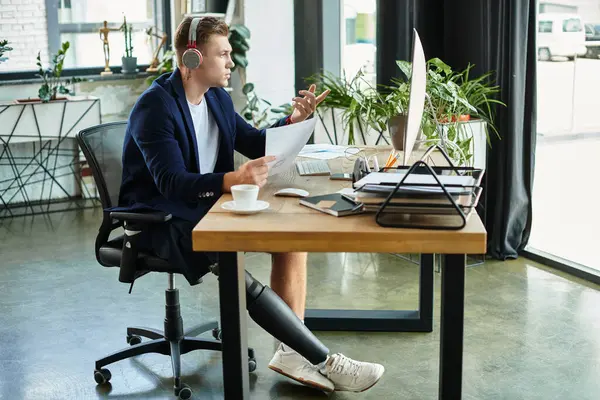 A professional man with a prosthetic leg actively participates in a business meeting from his office. — Stock Photo