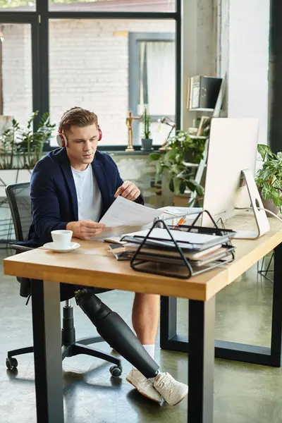 Um jovem profissional qualificado com uma perna protética se envolve com documentos em seu elegante espaço de trabalho de escritório. — Fotografia de Stock