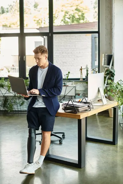 A young businessman with an artificial limb works confidently at his desk in a contemporary office. — Stock Photo