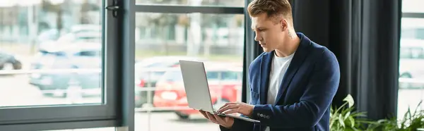 Um jovem profissional usando um laptop em um espaço de trabalho contemporâneo — Fotografia de Stock