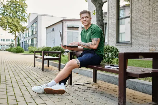 Um jovem com uma perna protética gosta de trabalhar ao ar livre em um banco cercado por vegetação e edifícios. — Fotografia de Stock