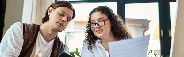 A young plus size woman and her male friend are engaged in a creative project together. — Stock Photo
