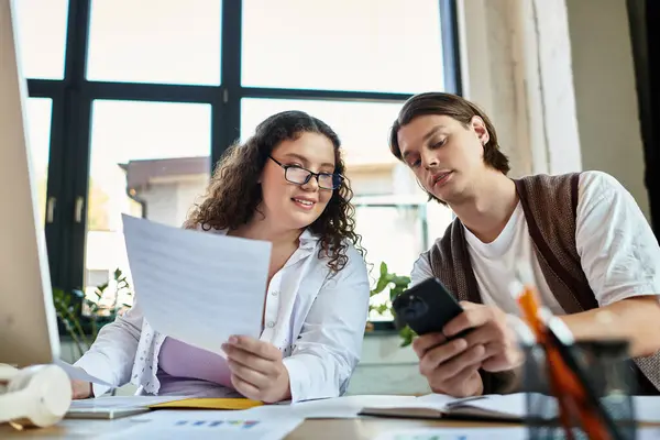 A young plus size woman and her male friend work together, sharing ideas and laughter. — Stock Photo