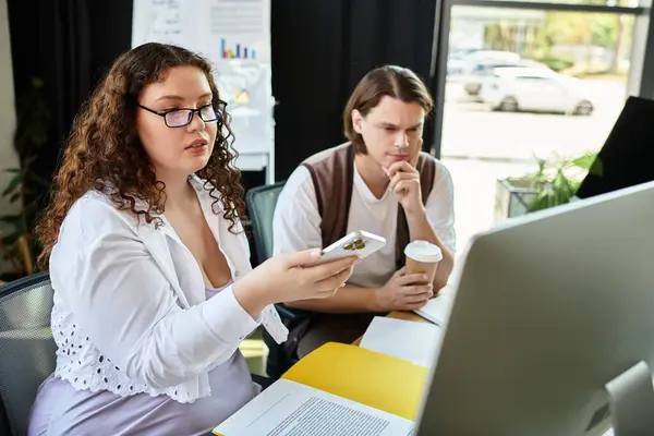 Uma jovem mulher plus size e seu amigo se envolver em uma discussão criativa em um espaço de trabalho brilhante. — Fotografia de Stock