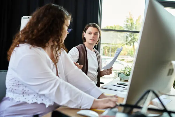 A young plus size woman engages in a lively conversation with her male friend at a work desk. — Stock Photo