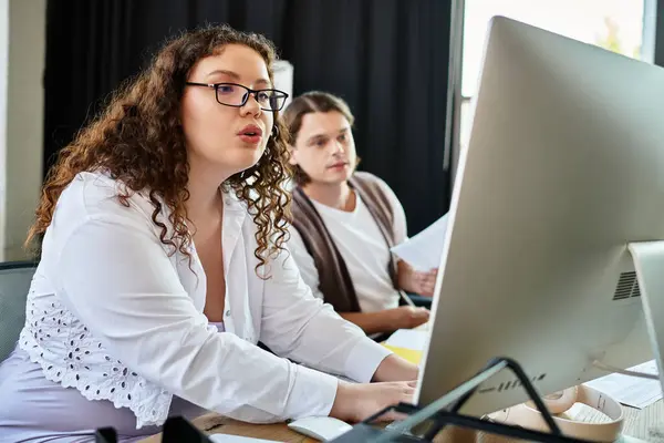 The young plus size woman actively engages with her male friend while working together. — Stock Photo