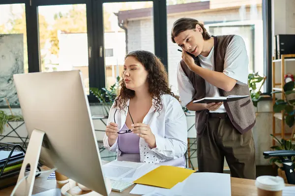 A plus size woman focuses on her screen while her friend offers ideas and support nearby. — Stock Photo