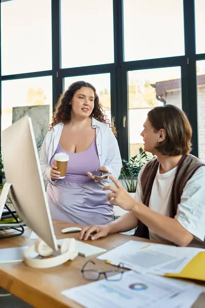 A young plus size woman chats with her male friend while holding a coffee cup in a bright room. — Stock Photo