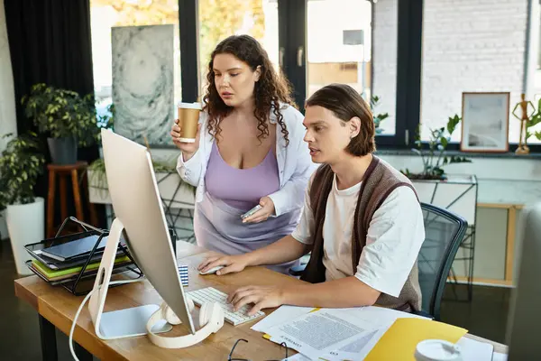 Una giovane donna plus size sostiene la sua amica mentre lavorano insieme a un progetto presso una scrivania. — Foto stock