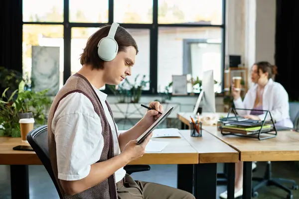 Una joven mujer de talla grande colabora con su amigo varón en un acogedor espacio de trabajo, absorto en tareas. - foto de stock
