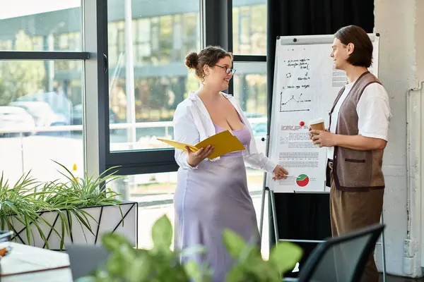 A young plus size woman shares ideas with her male friend while presenting colorful charts. — Stock Photo