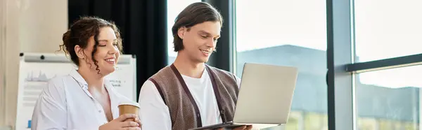 A plus size woman and her male friend share a cheerful moment while using a laptop together. — Stock Photo