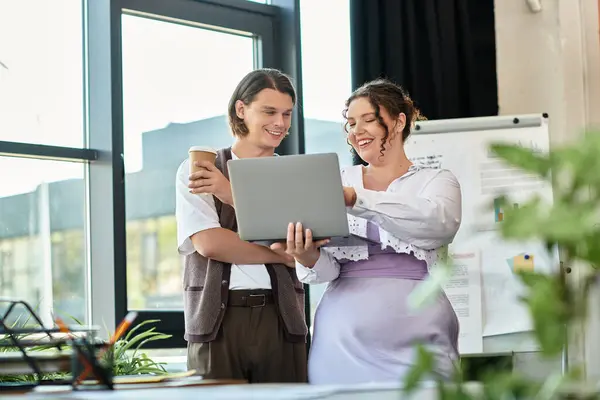 A cheerful young woman and her male friend discuss ideas over coffee and a laptop. — Stock Photo