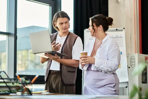 Two friends engage in a lively discussion while working on a laptop in a modern workspace. — Stock Photo