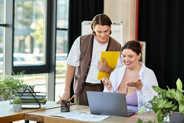 A cheerful plus size woman engages in discussion with her male friend while working on a laptop. — Stock Photo