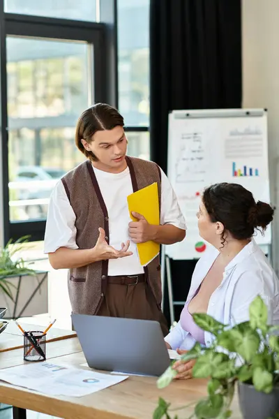 A plus size woman listens intently as her male friend discusses ideas in an office setting. — Stock Photo