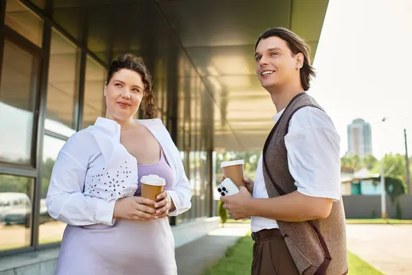 Une jeune femme heureuse plus la taille et son ami bavardent autour d'un café au soleil. — Photo de stock