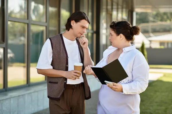 Una joven se involucra en una discusión profunda con su amiga mientras sostiene un cuaderno. - foto de stock