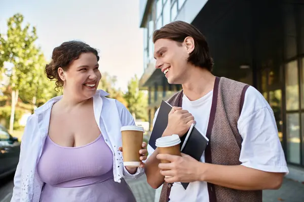 A young plus size woman and her male friend share smiles while holding coffee cups outdoors. — Stock Photo