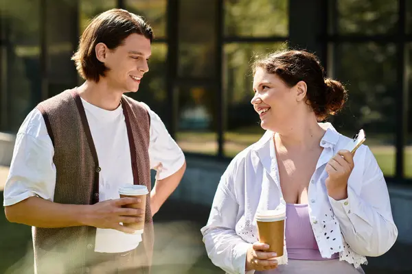 Une jeune femme profite d'une conversation animée avec son ami tout en sirotant du café à l'extérieur. — Photo de stock