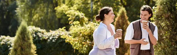 A young woman and her male friend share laughs while enjoying coffee outdoors under the sun. — Stock Photo