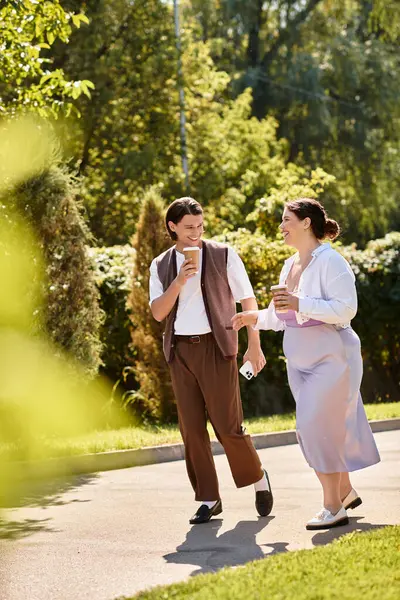 Two friends delight in each others company during a sunny afternoon stroll, coffee in hand. — Stock Photo