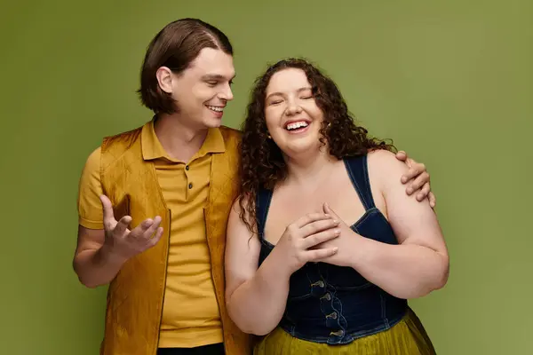 A young plus size woman laughs with her male friend in a lively and colorful atmosphere. — Stock Photo