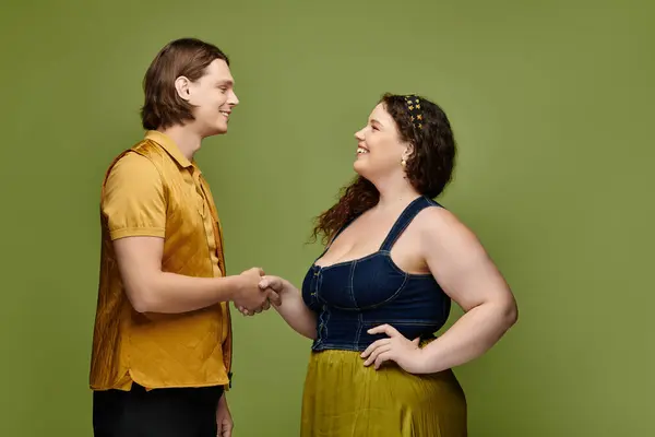 Молодая женщина plus size и ее друг-мужчина обмениваются дружеским рукопожатием в веселой атмосфере. — стоковое фото