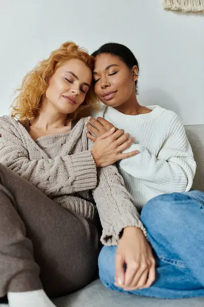 Two women embrace each other gently while enjoying a quiet moment at home together. — Stock Photo