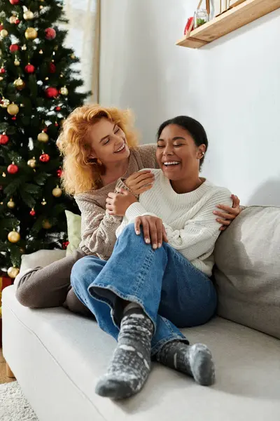 Two happy women share a cozy moment on the sofa, enjoying each others laughter and warmth. — Stock Photo