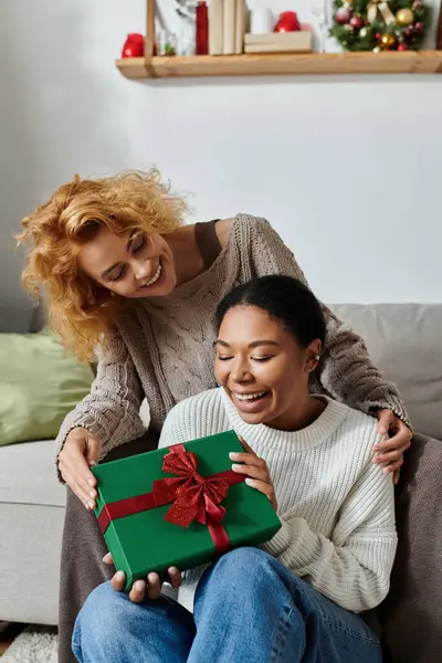 A joyful couple enjoys a special moment together as they open a surprise present. — Stock Photo