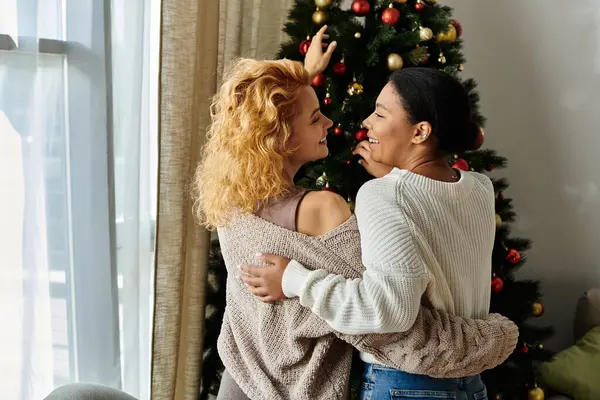 A beautiful couple enjoys decorating their cozy living space during the festive season. — Stock Photo
