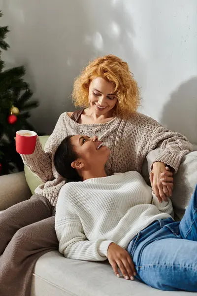 Una pareja amorosa disfruta de un momento acogedor juntos, compartiendo sonrisas y calidez en su espacio vital. - foto de stock