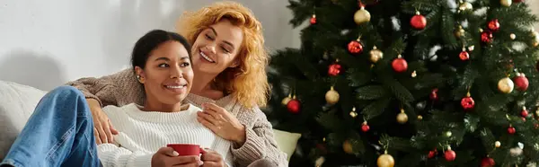 Dois indivíduos felizes relaxam juntos na árvore de Natal, compartilhando calor e amor. — Fotografia de Stock