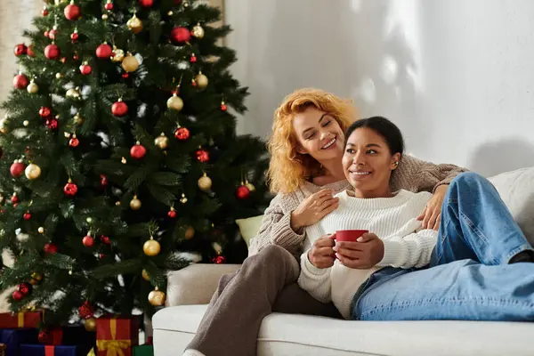 Ein Paar genießt Gesellschaft auf einem gemütlichen Sofa, umgeben von Weihnachtsdekorationen. — Stockfoto