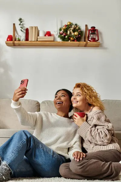 Two women celebrate their bond while taking a fun selfie on a relaxing day indoors. — Stock Photo