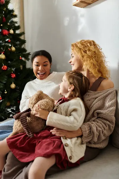 Un moment chaleureux et aimant partagé par un beau couple et leur fille près du sapin de Noël. — Photo de stock