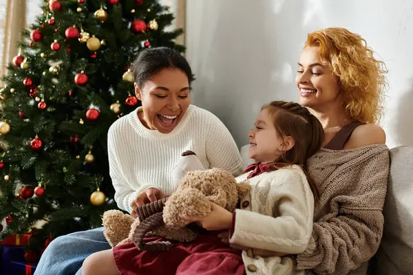 Um belo casal compartilha o riso com sua filha enquanto celebra as férias. — Stock Photo