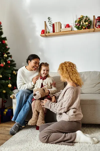 A joyful couple shares laughter and warmth with their daughter at home during the holidays. — Stock Photo