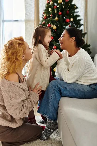 A loving couple enjoys precious moments with their daughter in a cozy living room setting. — Stock Photo