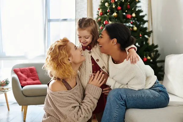 Una coppia amorevole condivide una risata con la figlia in un accogliente spazio abitativo pieno di gioia. — Foto stock