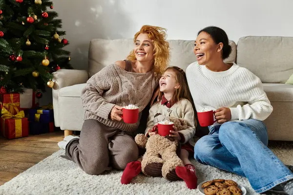 A couple shares a cozy moment with their daughter, filled with laughter and warmth. — Stock Photo
