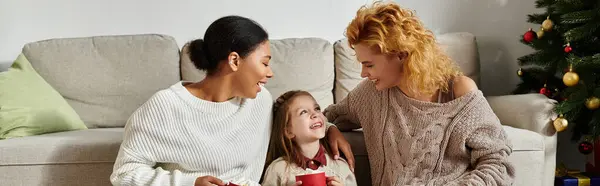 A loving couple shares a joyful moment with their daughter while cozying up at home. — Stock Photo