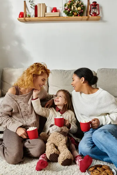 Une famille joyeuse profite d'un moment agréable ensemble, partageant des sourires et des boissons chaudes à la maison. — Photo de stock