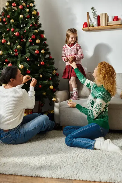 A loving couple shares tender moments with their daughter while decorating for Christmas. — Stock Photo