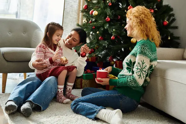 Una coppia felice e la loro figlia festeggiano insieme a casa, godendo l'atmosfera festosa. — Foto stock